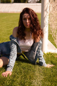 Portrait of young woman sitting on grassy field