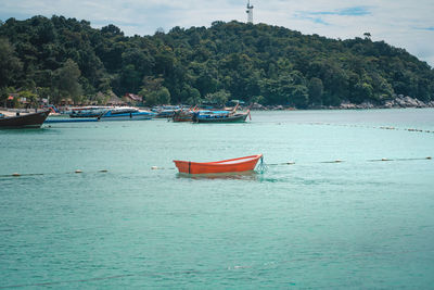 Boat moored in sea against sky