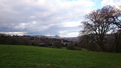 Scenic view of grassy field against cloudy sky