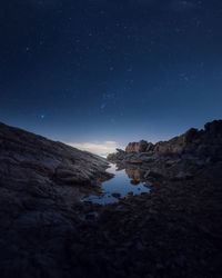 Rock formations against sky at night