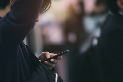 Midsection of man using mobile phone