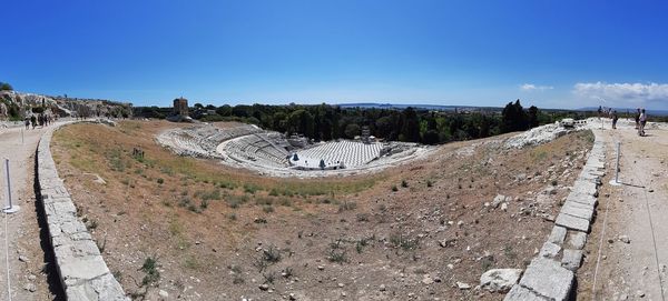 Panoramic view of old ruins against blue sky