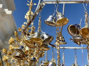 Low angle view of decorations hanging against blue sky