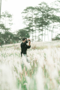 Portrait of man with his camera in the middle of white reeds