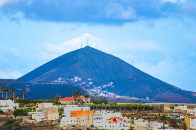 Buildings in city against cloudy sky