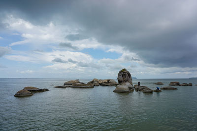 Rocks in sea against sky