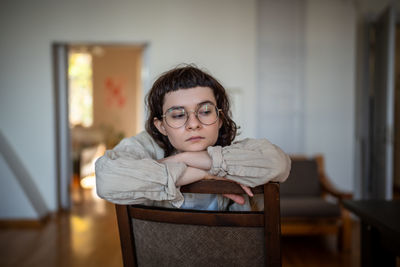 Portrait of young woman sitting on table at home