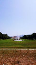 View of grassy field against clear sky