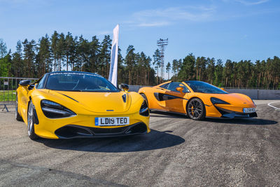 Yellow car on road against blue sky