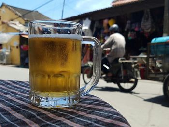 Close-up of beer mug on table at sidewalk cafe