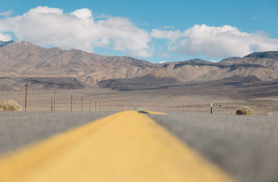 Scenic view of road by mountains against sky