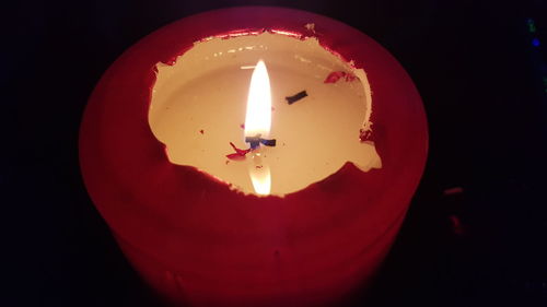 Close-up of illuminated lamp over black background