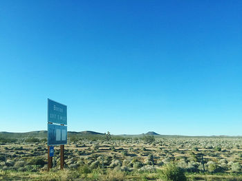 Text on field against clear blue sky