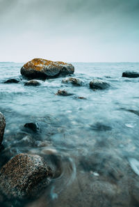 View of rocks in sea against sky