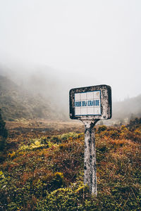 Information sign on landscape against sky