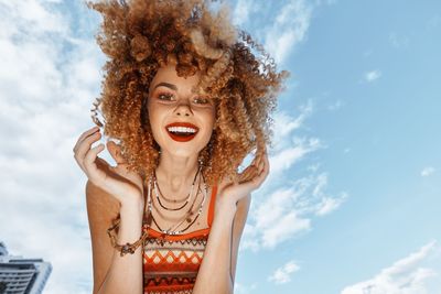 Low angle view of woman looking away against sky