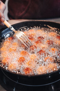 Close-up of person preparing food in pan