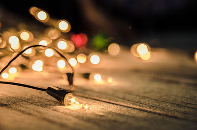 Close-up of illuminated string lights on table during christmas