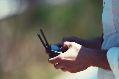 Midsection of man using remote control