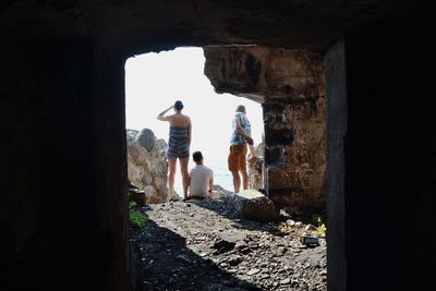 Rear view of people standing in abandoned building