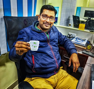 Portrait of young man sitting on chair