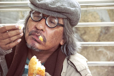 Man looking away while eating food