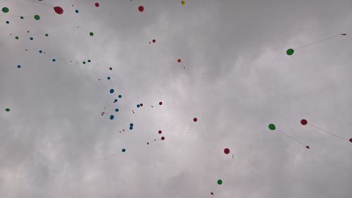 Low angle view of balloons flying against sky