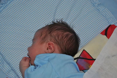 High angle view of child lying in crib