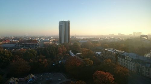 Illuminated cityscape against sky during sunset