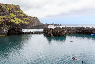 View of people swimming in the pool against the sky