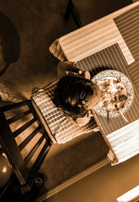 Directly above shot of girl eating food sitting by table