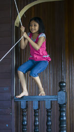 Smiling girl hanging on rope