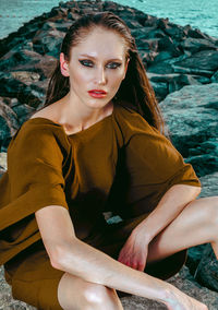 Portrait of young woman sitting at beach