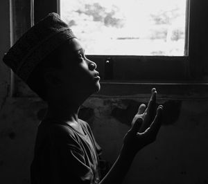 Side view of man looking through window