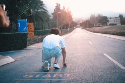 Rear view of man with umbrella on street