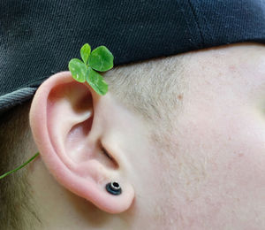 Close-up of man wearing leaf on ear