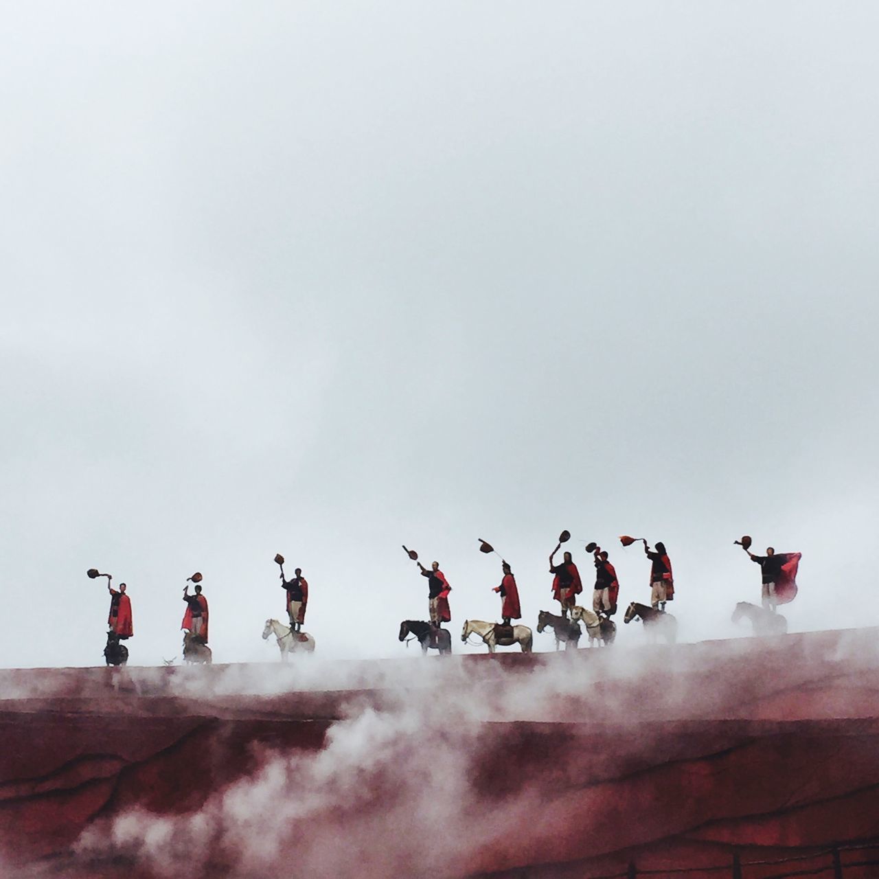 large group of people, men, lifestyles, sky, flying, leisure activity, person, copy space, mid-air, low angle view, in a row, flag, mixed age range, teamwork, enjoyment, outdoors, order, bird, togetherness