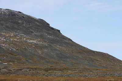 Low angle view of rocky mountain against sky