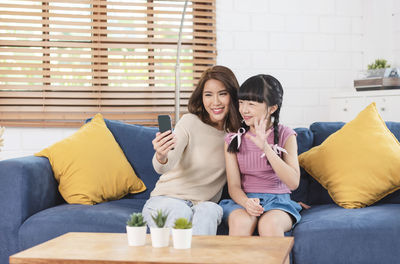 Young woman sitting on sofa at home