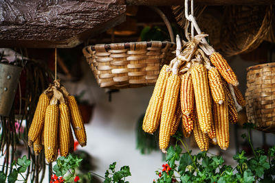 Corn on the cobs and wicker baskets hanging