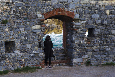 Low angle view of girl walking on stone wall