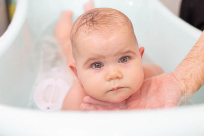 Portrait of cute baby girl in bathtub at home