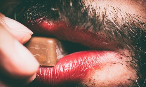 Extreme close up of a man eating chocolate