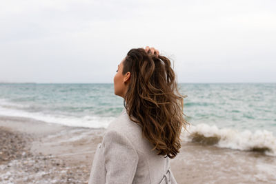 Woman looking at sea against sky