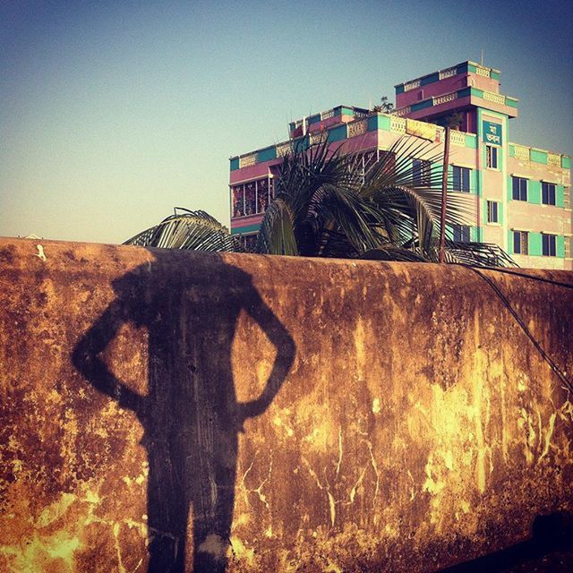 building exterior, architecture, built structure, clear sky, low angle view, sunlight, shadow, outdoors, sky, building, bicycle, wall - building feature, day, no people, land vehicle, house, old, abandoned, residential structure