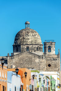 Low angle view of temple against clear blue sky during sunny day