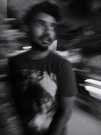 Blurred motion of man with arms raised at night