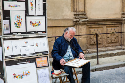 Full length of man sitting on table