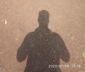 Shadow of man standing on road