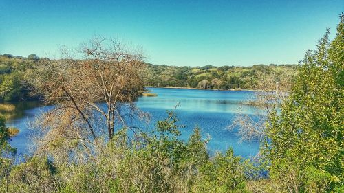 Scenic view of lake against clear blue sky